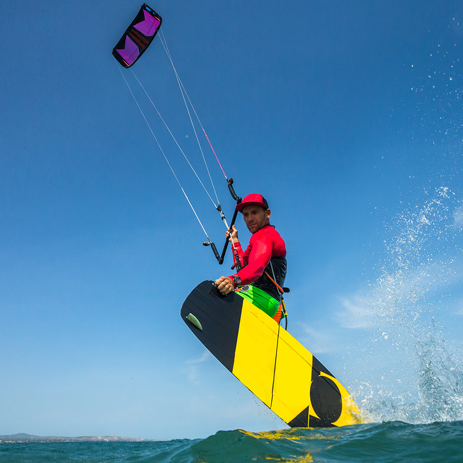Kitesurfer springt über die Wellen des Gardasees bei windigem Wetter in Brenzone